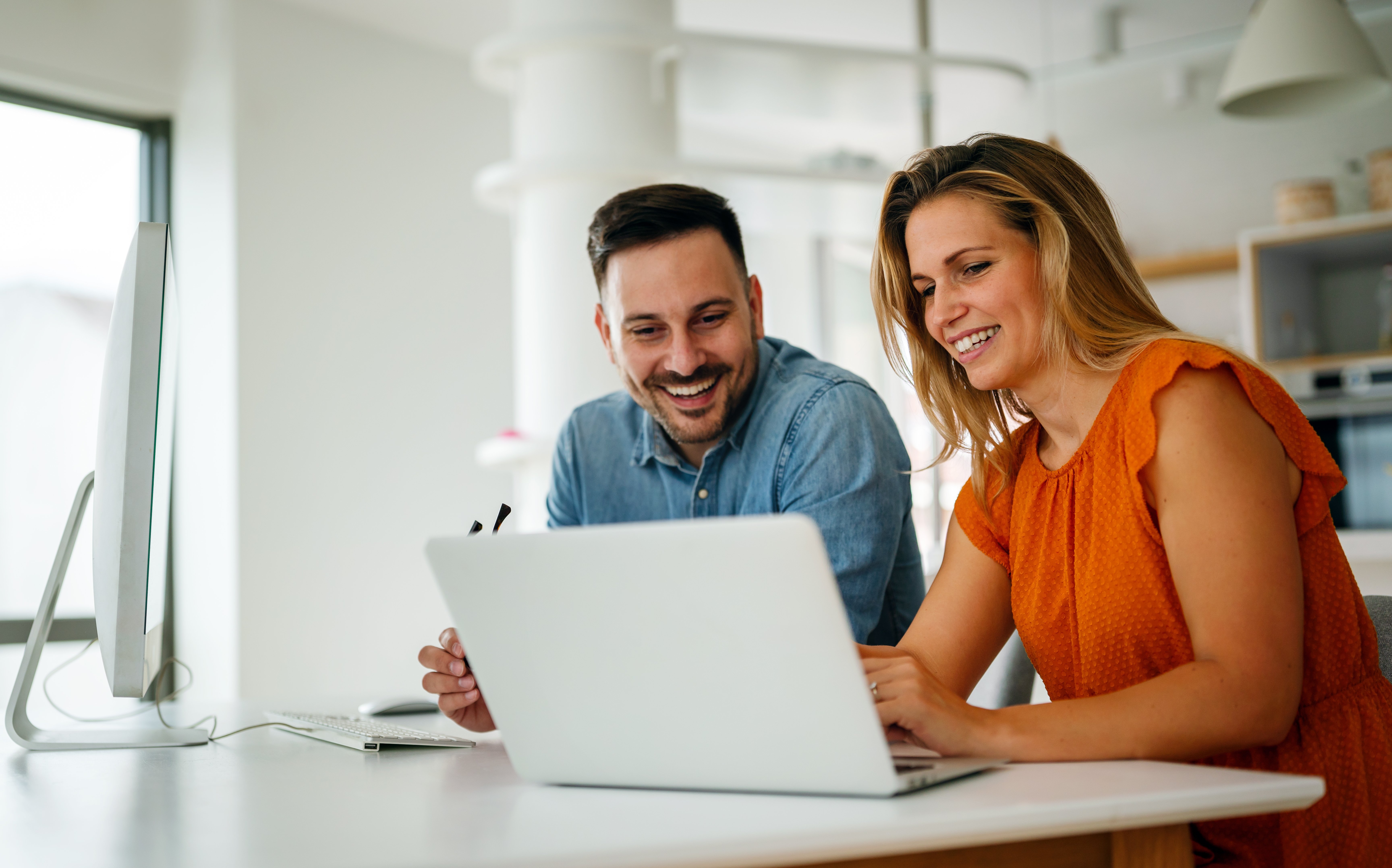 Two colleagues happily discussing a project